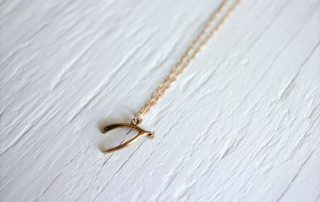 gold wishbone necklace on a gold chain