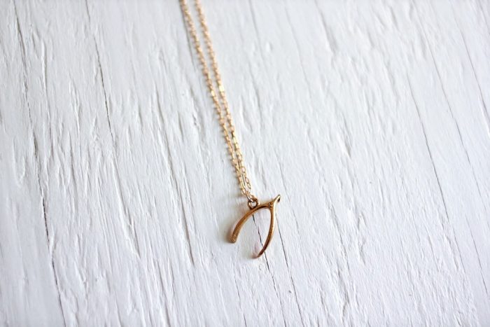 gold wishbone necklace on a gold chain