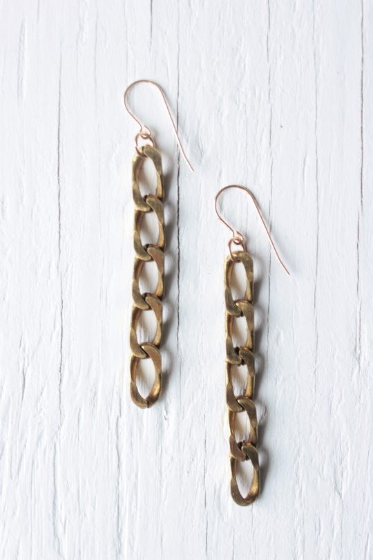 Gold chain earrings on white background