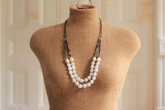 White Bead necklace featuring 2 layers of strands, worn on a mannequin in front of a white background