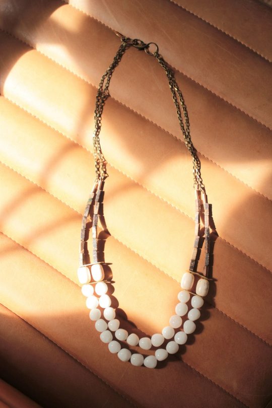white stone necklace with 2 layers laying on a tan leather background